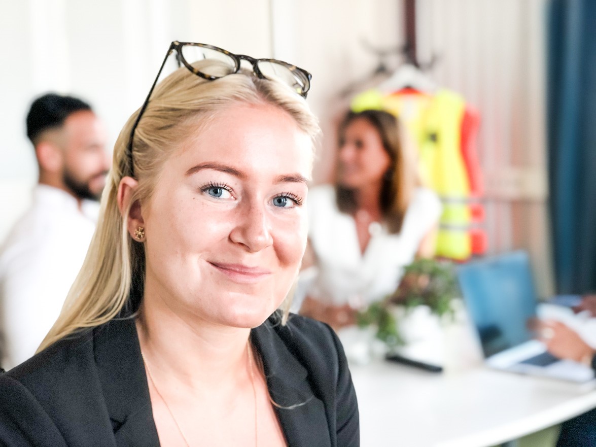 Emma Göhle med medarbetare i bakgrunden.